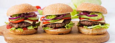 Big sandwich - hamburger burger with beef, avocado, tomato and red onions on light background. American cuisine. Banner. Fast Food